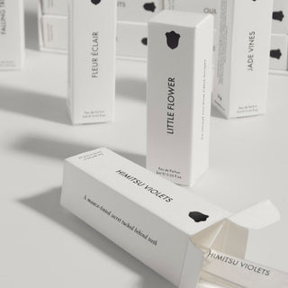 White perfume boxes with black text on a light gray background